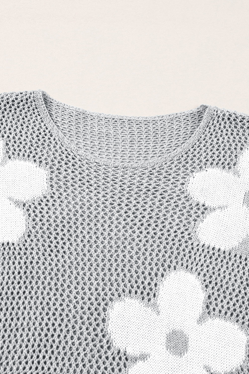 Hellgrauer Strickpullover mit großer Blume und überschnittener Schulter