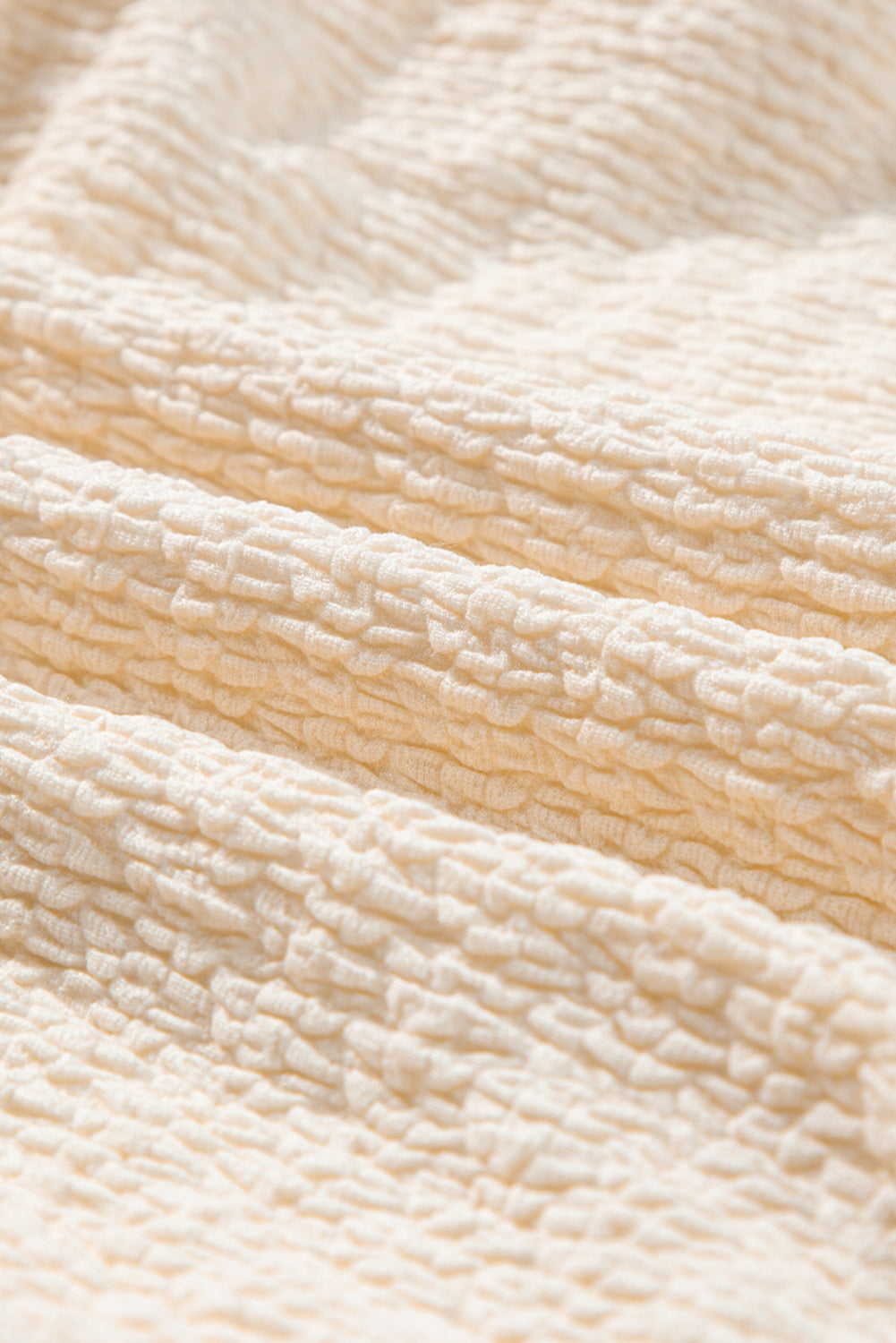 Beiges strukturiertes Minikleid mit tiefem V-Ausschnitt und Cut-Out auf der Rückseite