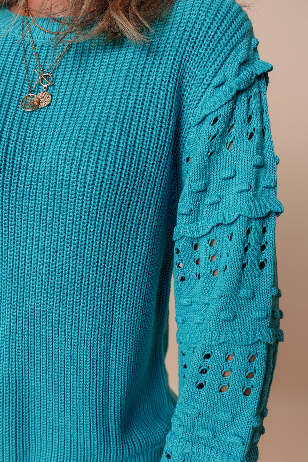 Türkisfarbener Pullover mit gerüschten Ösenärmeln