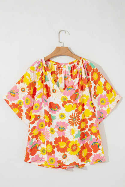 Orangefarbene Bluse mit V-Ausschnitt und halblangen Ärmeln und abstraktem Print
