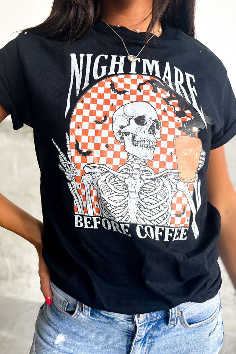 Schwarzes Halloween-T-Shirt mit Totenkopf-Schachbrett-Grafik von Nightmare Before Coffee