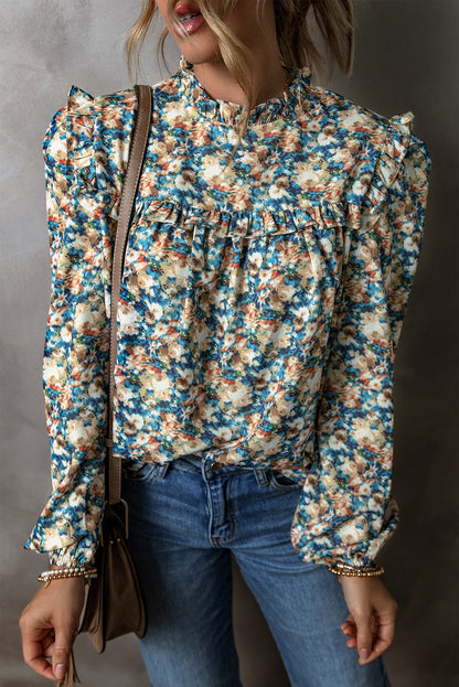 Himmelblaue Bluse mit Blumenmuster, Rüschen und Stehkragen sowie Puffärmeln