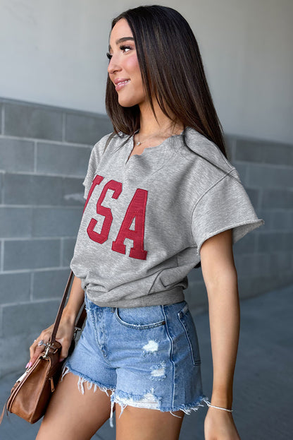 Hellgraues, lockeres T-Shirt mit USA-Schriftzug-Patch und eingekerbtem Ausschnitt