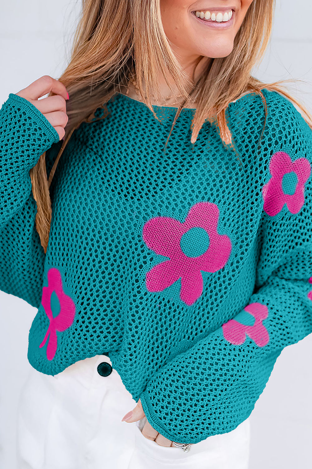 Seegrüner Strickpullover mit großer Blume und tief angesetzten Schultern