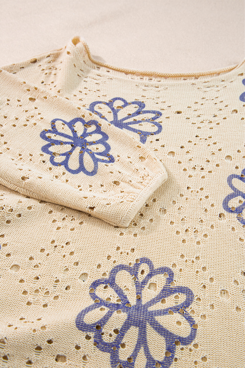 Beigefarbener Pullover mit kontrastierendem Blumenmuster und überschnittener Schulter