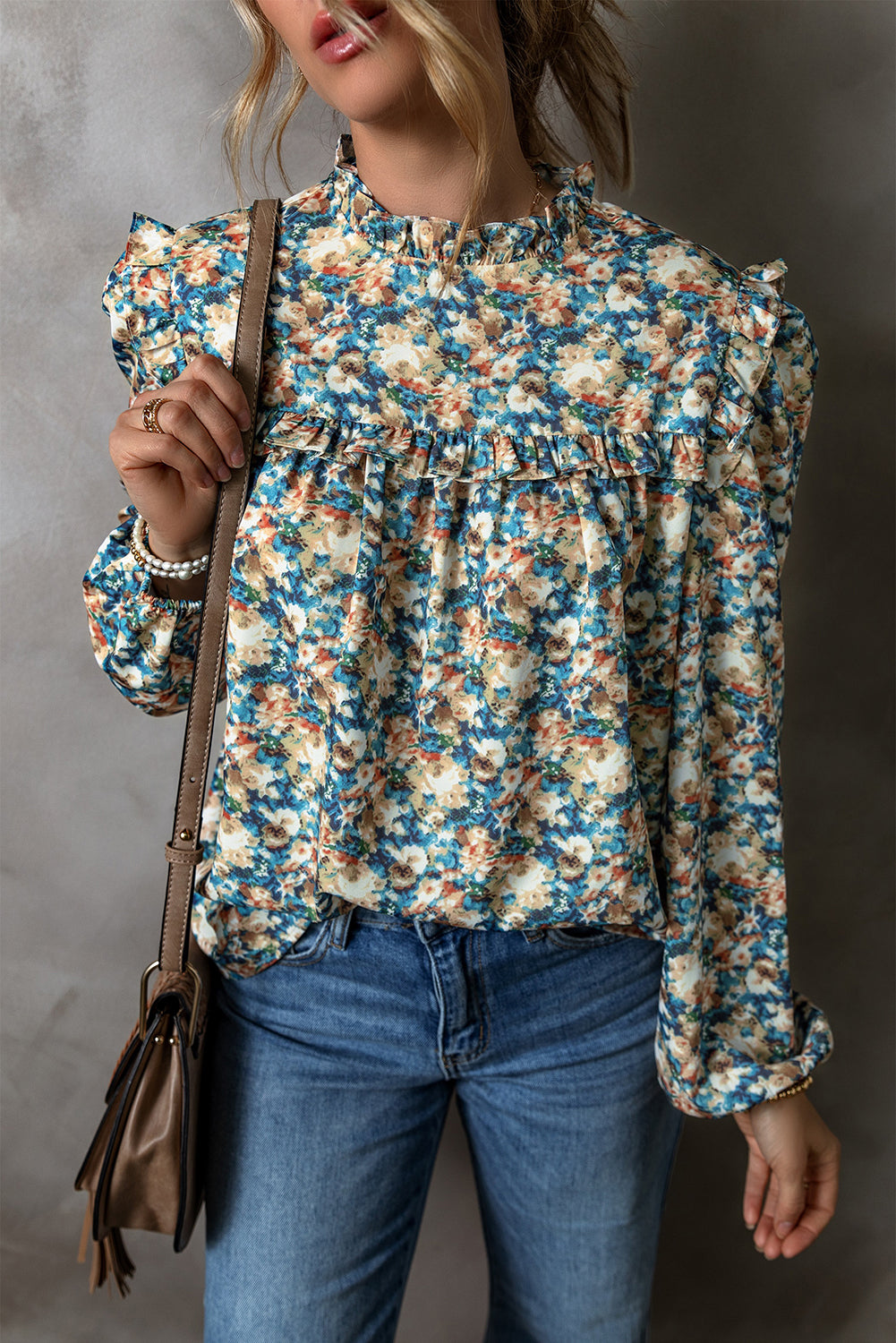 Himmelblaue Bluse mit Blumenmuster, Rüschen und Stehkragen sowie Puffärmeln