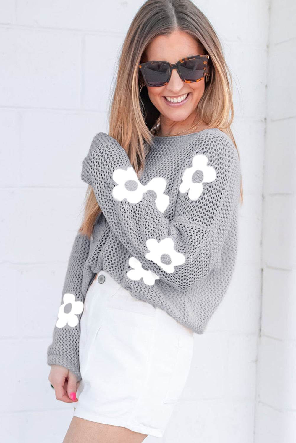 Hellgrauer Strickpullover mit großer Blume und überschnittener Schulter