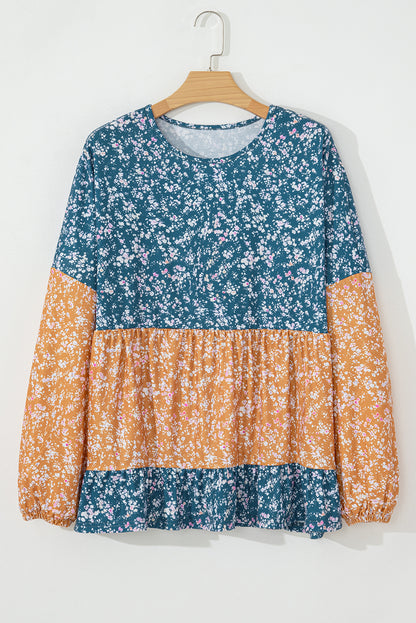 Orangefarbene Bluse mit Blumenmuster, Farbblockdesign, Rüschensaum und Rundhalsausschnitt