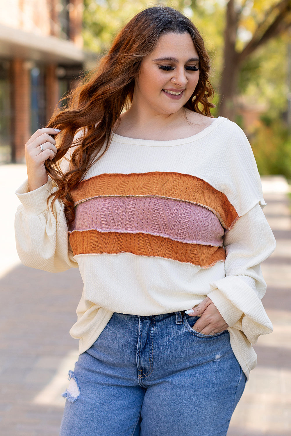 Weißes Stricktop mit Patchwork-Muster und sichtbaren Nähten sowie langen Ärmeln