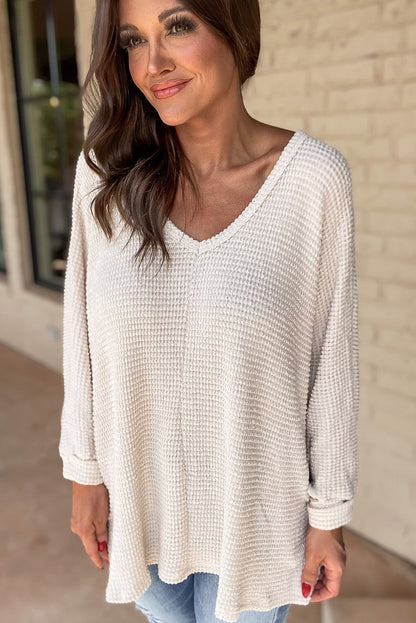 Weißes, locker sitzendes Oberteil aus Waffelstrick mit Seitenschlitzen und V-Ausschnitt
