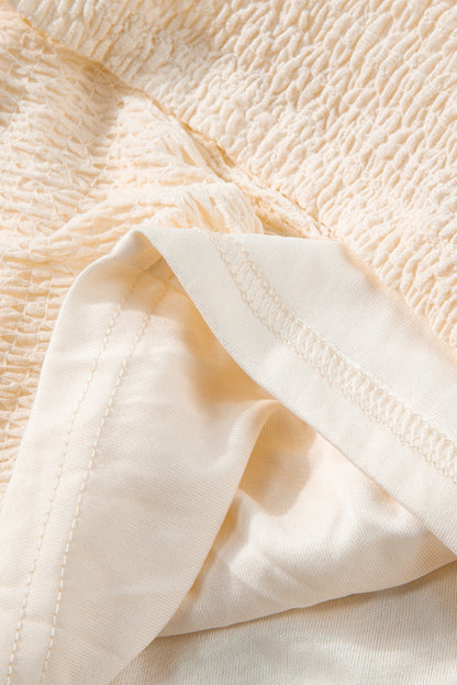 Beiges strukturiertes Minikleid mit tiefem V-Ausschnitt und Cut-Out auf der Rückseite