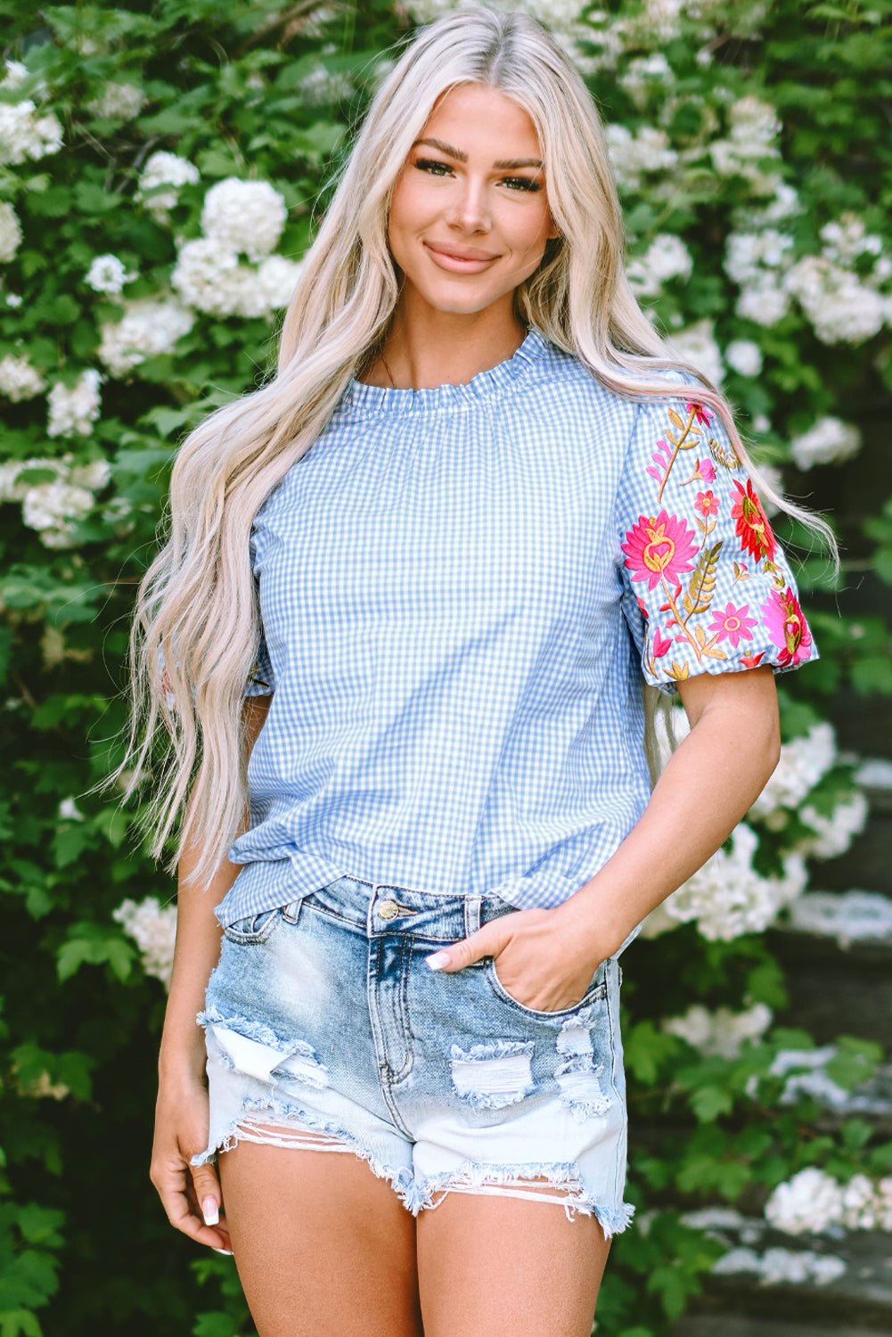 Hellblaue Bluse mit Puffärmeln und Blumenstickerei im Gingham-Stil