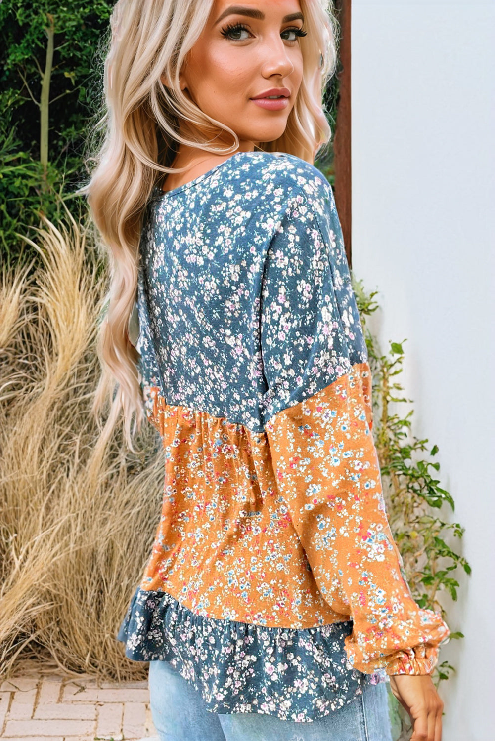 Orangefarbene Bluse mit Blumenmuster, Farbblockdesign, Rüschensaum und Rundhalsausschnitt