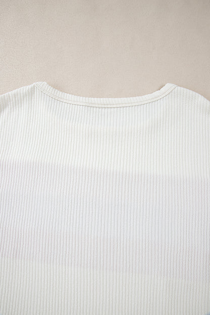 Weißes Stricktop mit Patchwork-Muster und sichtbaren Nähten sowie langen Ärmeln