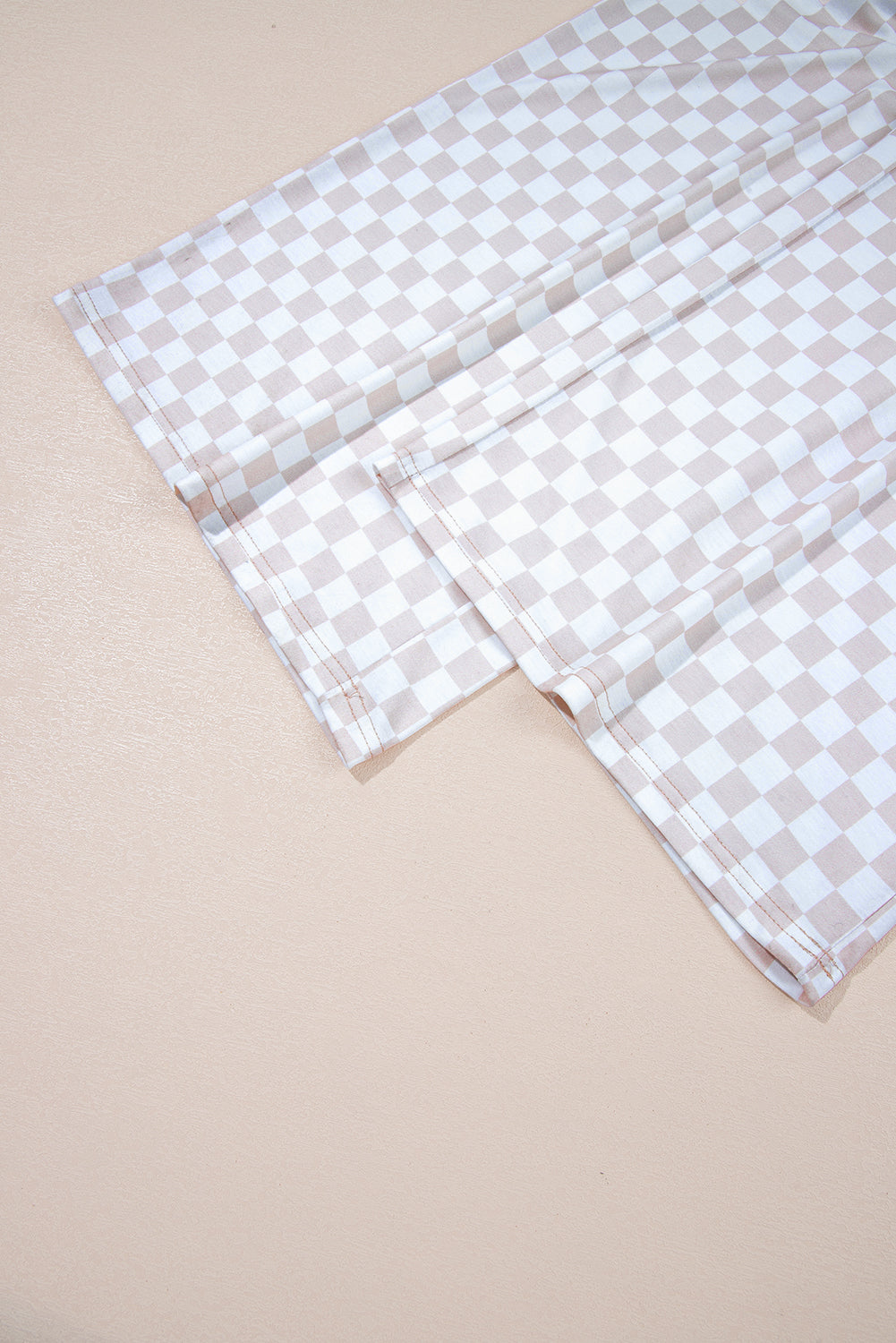 Aprikosenfarbener Jumpsuit mit weitem Bein und Karomuster, Rundhalsausschnitt und Knöpfen