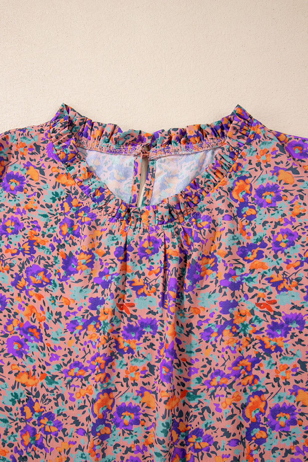 Lila Bluse mit Rundhalsausschnitt, Blumenmuster und gerafften Bündchen