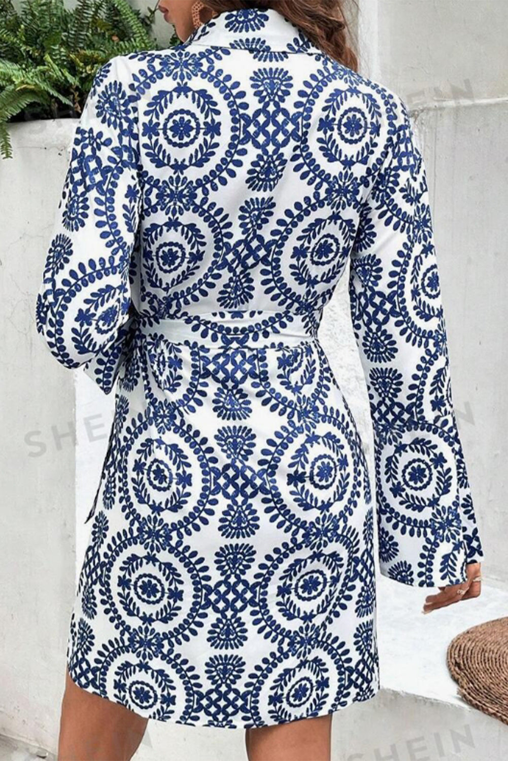 Blaues Kleid mit Blumenmuster, V-Ausschnitt, Wickelknoten und langen Ärmeln