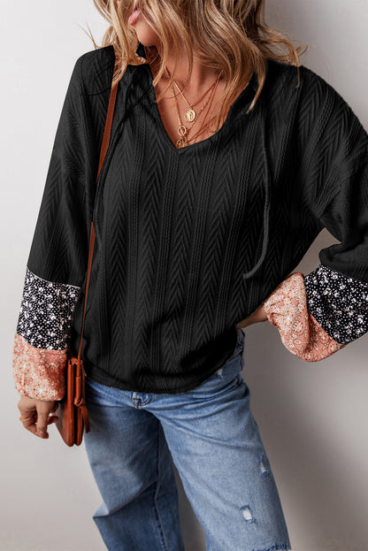 Schwarze Bluse mit V-Ausschnitt und floralem Patchwork-Muster
