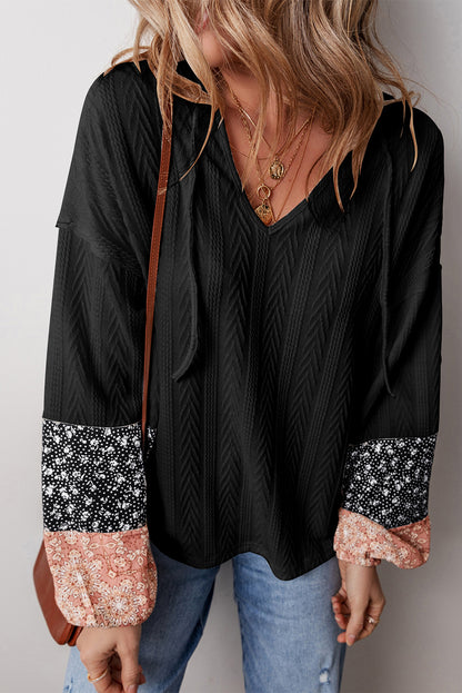 Schwarze Bluse mit V-Ausschnitt und floralem Patchwork-Muster