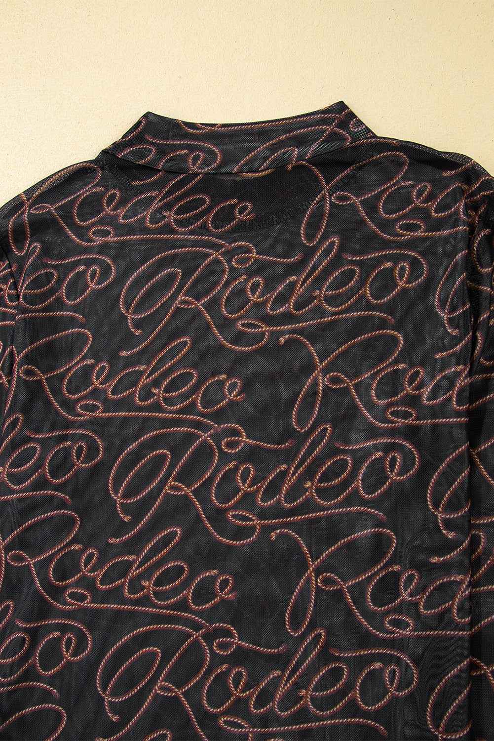 Schwarzes, langärmliges Netzoberteil mit Stehkragen und Western-Rodeo-Print