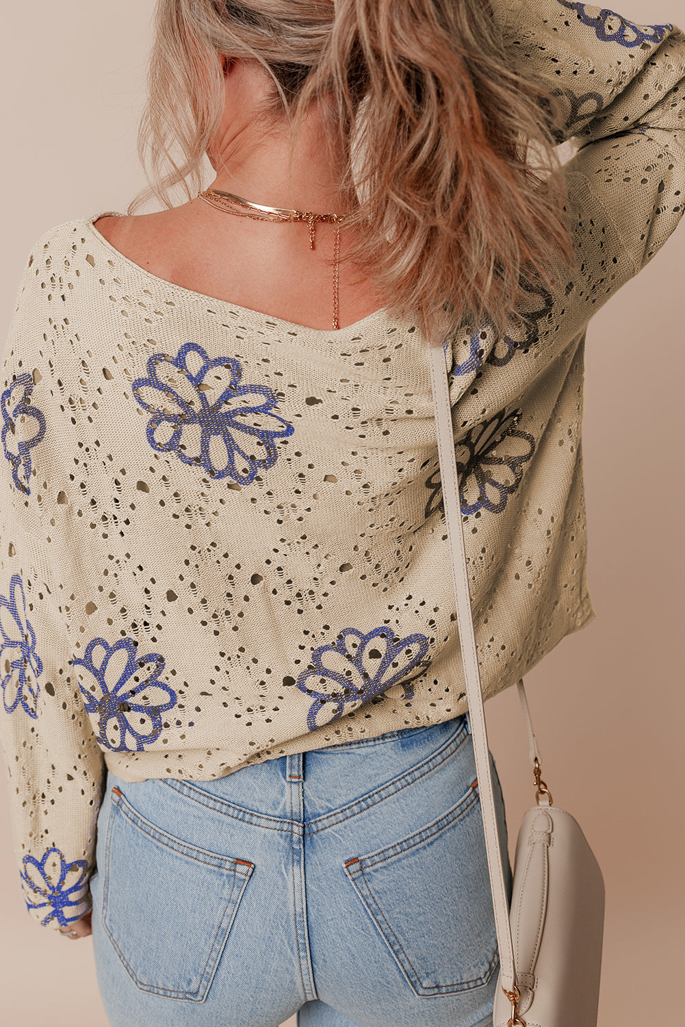 Beigefarbener Pullover mit kontrastierendem Blumenmuster und überschnittener Schulter