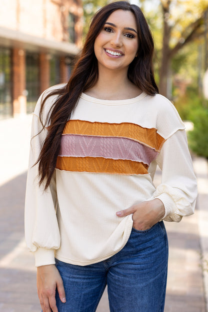 Weißes Stricktop mit Patchwork-Muster und sichtbaren Nähten sowie langen Ärmeln
