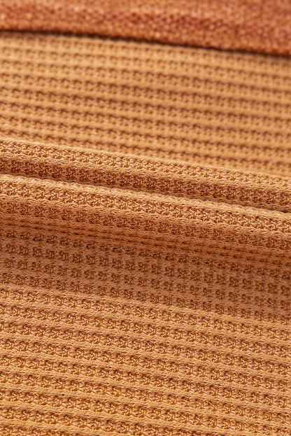 Orangefarbenes Henley-Oberteil aus Waffelstrick mit kontrastierenden Flicken und sichtbaren Nähten