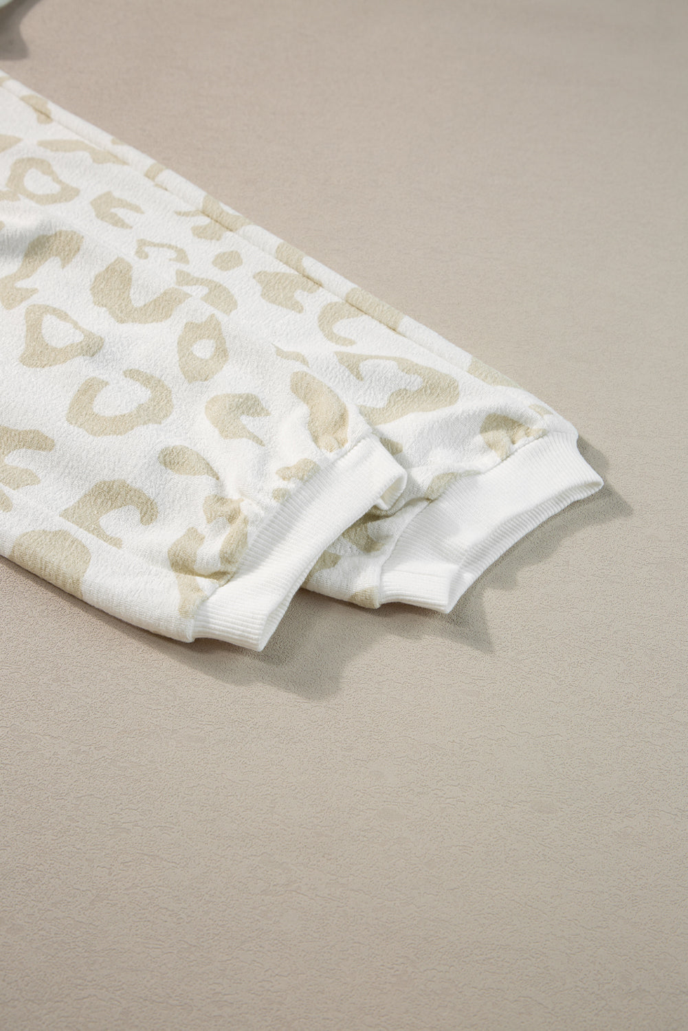 Lounge-Set aus weißem Pullover mit Leopardenmuster und Hose mit Kordelzug