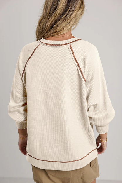 Beiges Pullover-Oberteil aus strukturiertem Strick mit sichtbaren Nähten und V-Ausschnitt