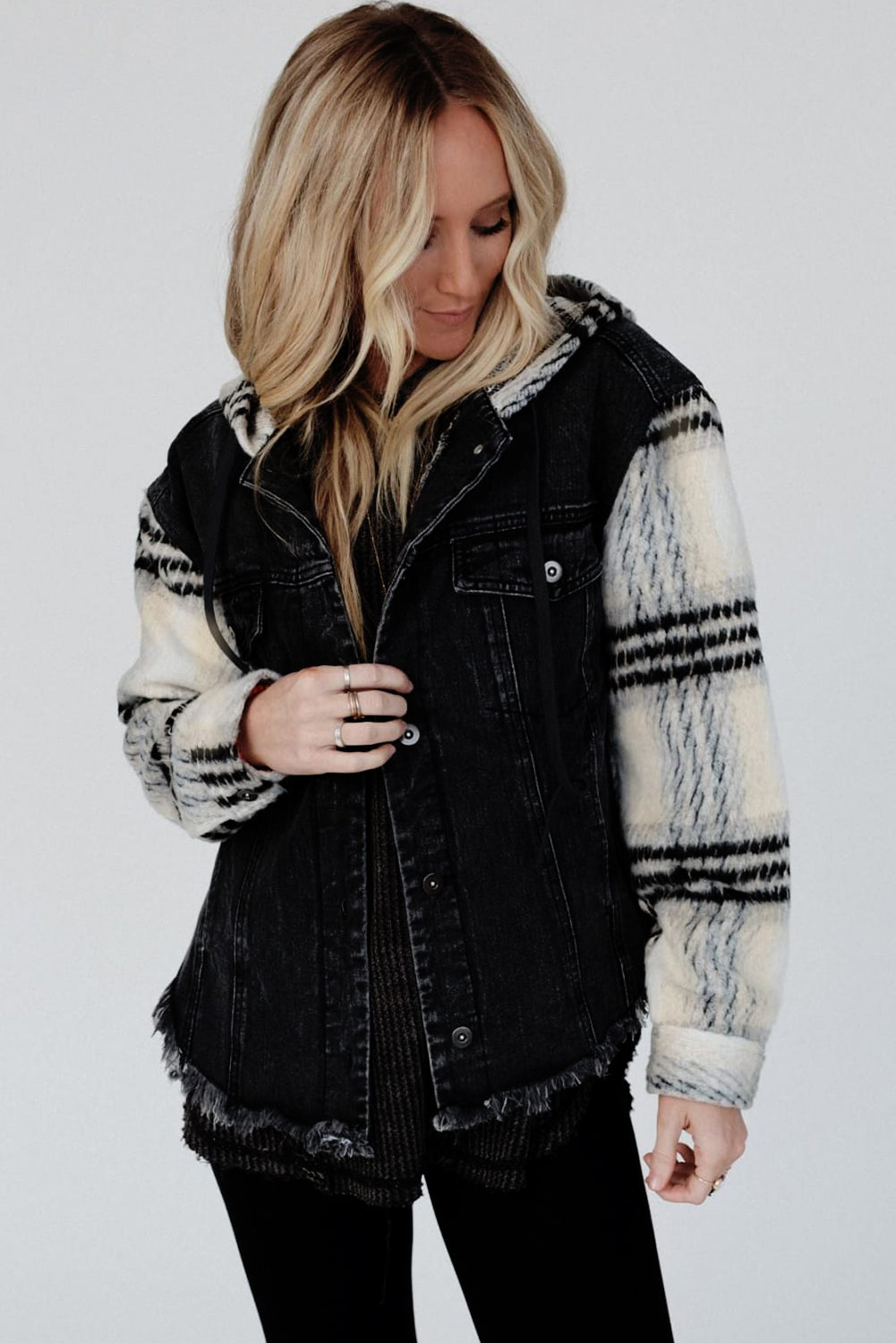 Schwarze Jeansjacke mit Kapuze und karierten Ärmeln und ausgefranstem Saum