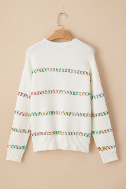 Weißer Pullover mit bunten Kreuzstichen und überschnittenen Schultern