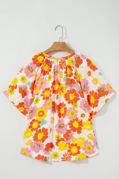 Orangefarbene Bluse mit V-Ausschnitt und halblangen Ärmeln und abstraktem Print