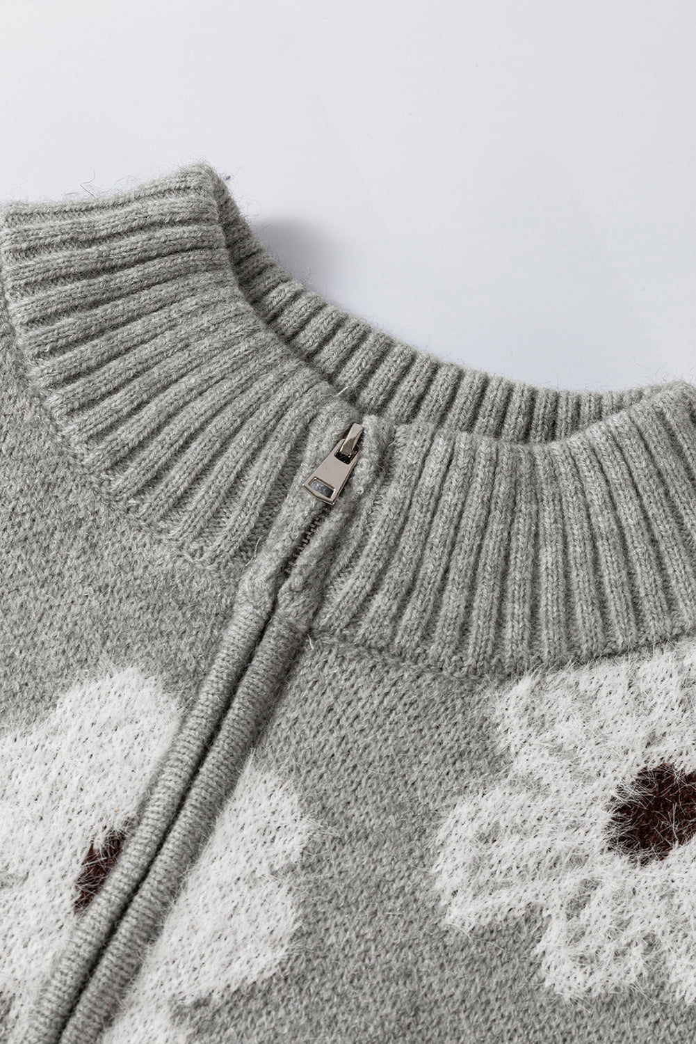 Grauer Pullover mit Blumenmuster und halblangem Reißverschluss sowie überschnittenen Schultern