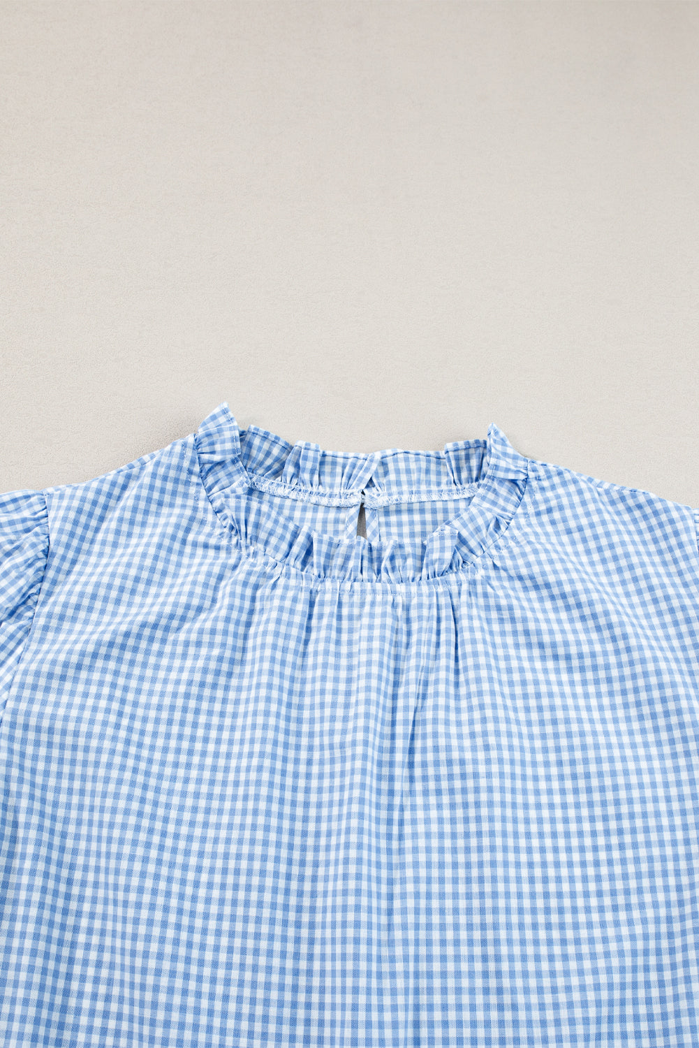 Hellblaue Bluse mit Puffärmeln und Blumenstickerei im Gingham-Stil