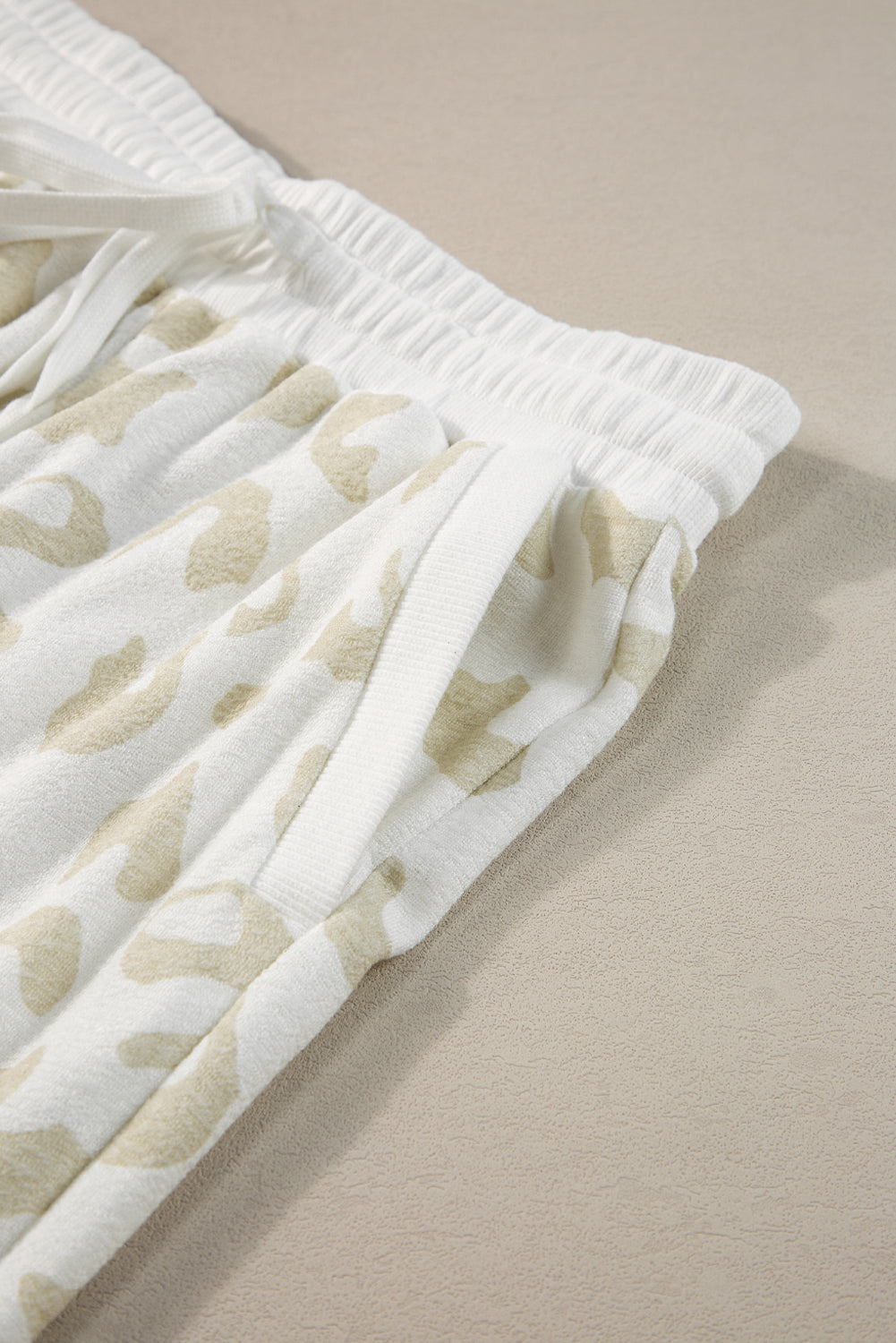 Lounge-Set aus weißem Pullover mit Leopardenmuster und Hose mit Kordelzug