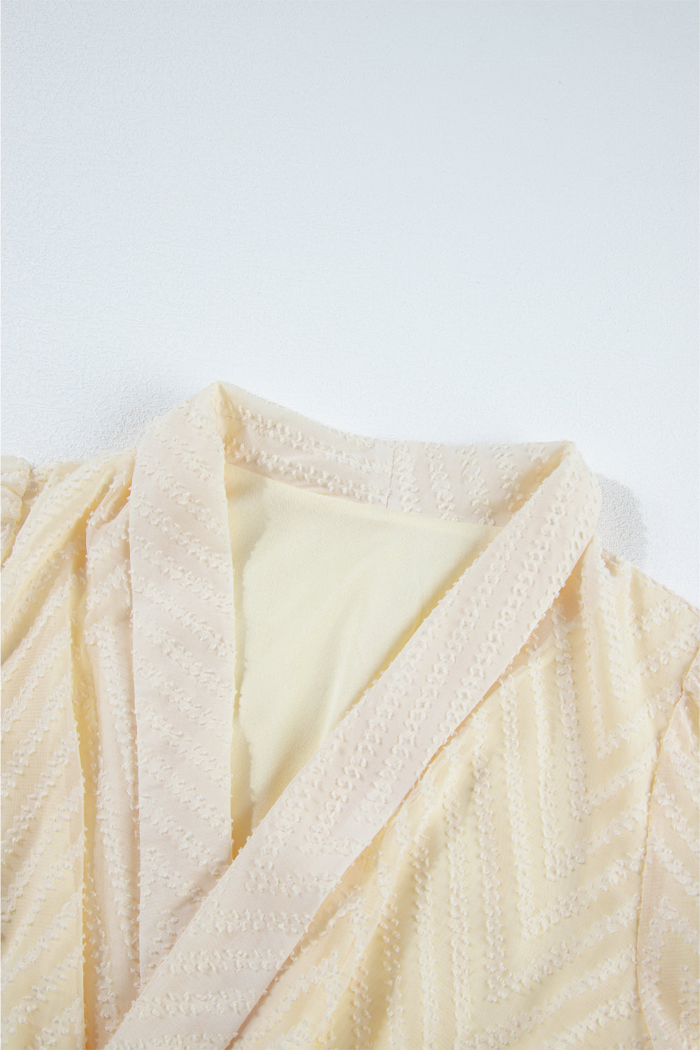 Aprikosenfarbenes Minikleid mit V-Ausschnitt, transparenten Puffärmeln und Knoten