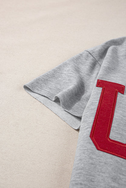 Hellgraues, lockeres T-Shirt mit USA-Schriftzug-Patch und eingekerbtem Ausschnitt