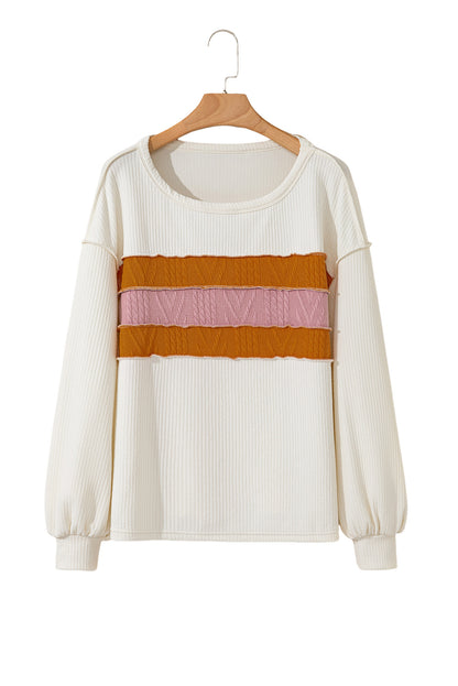 Weißes Stricktop mit Patchwork-Muster und sichtbaren Nähten sowie langen Ärmeln