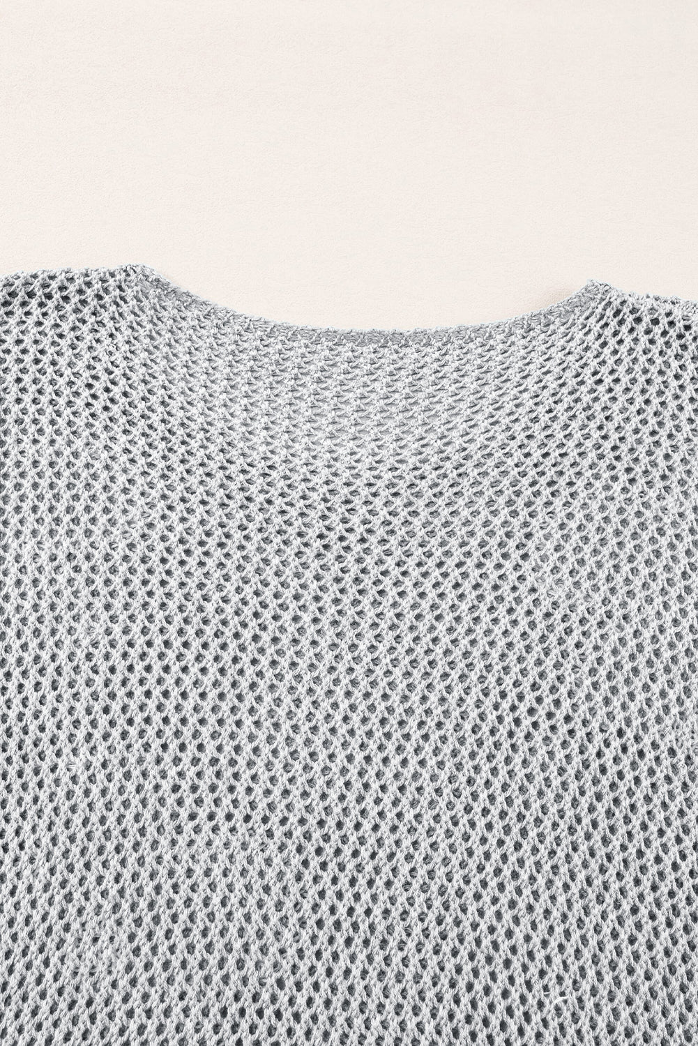 Hellgrauer Strickpullover mit großer Blume und überschnittener Schulter