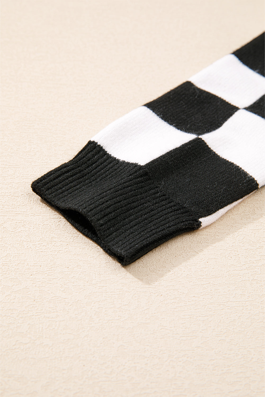 Schwarzer Pullover mit Karomuster und überschnittener Schulterpartie und Rundhalsausschnitt