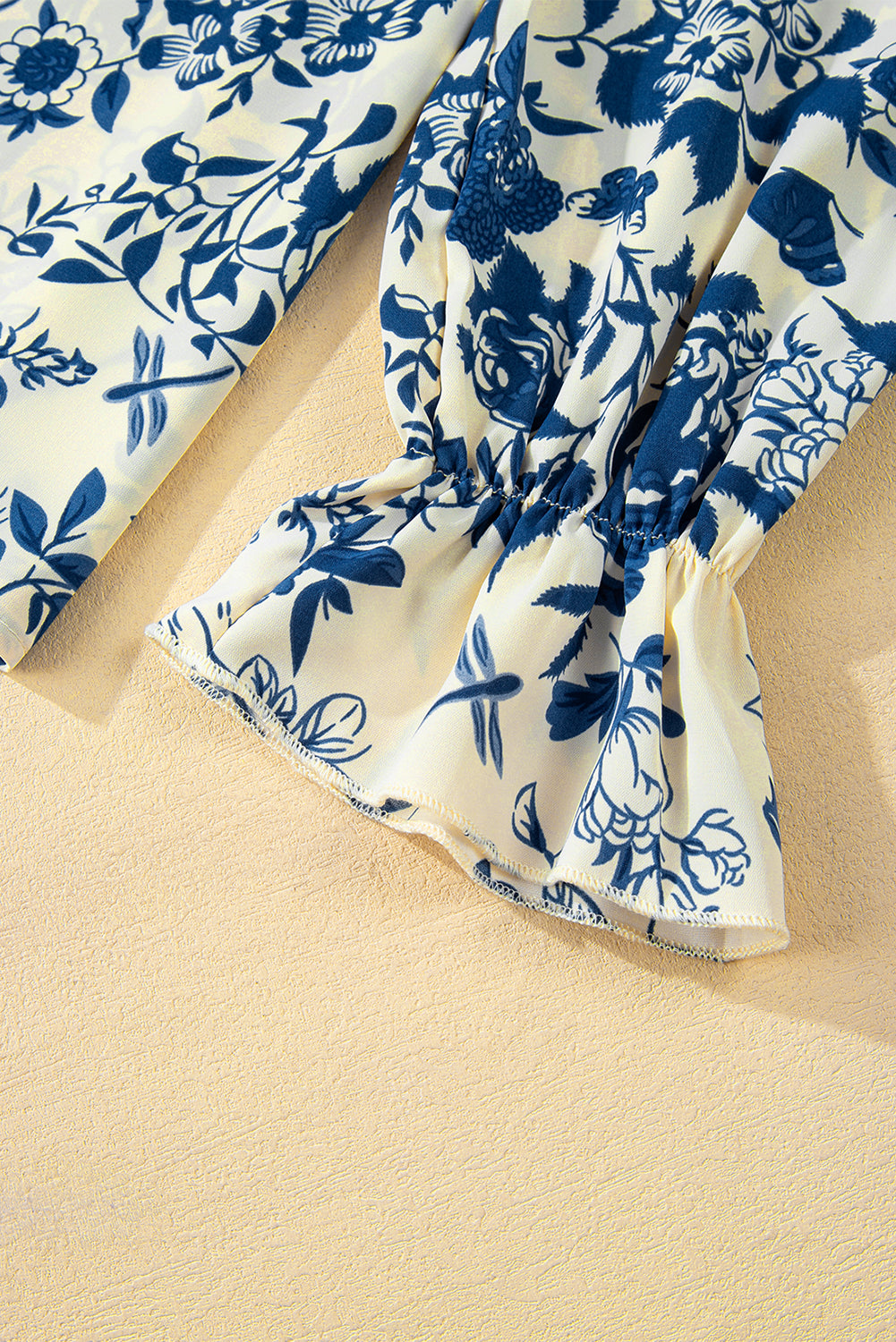 Himmelblaue Bluse mit Blumenmuster, Volantärmeln und Schlüsselloch hinten