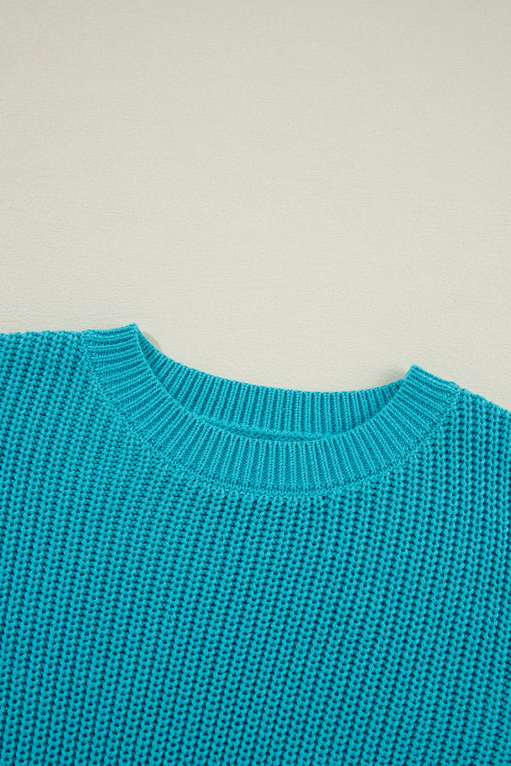 Türkisfarbener Pullover mit gerüschten Ösenärmeln