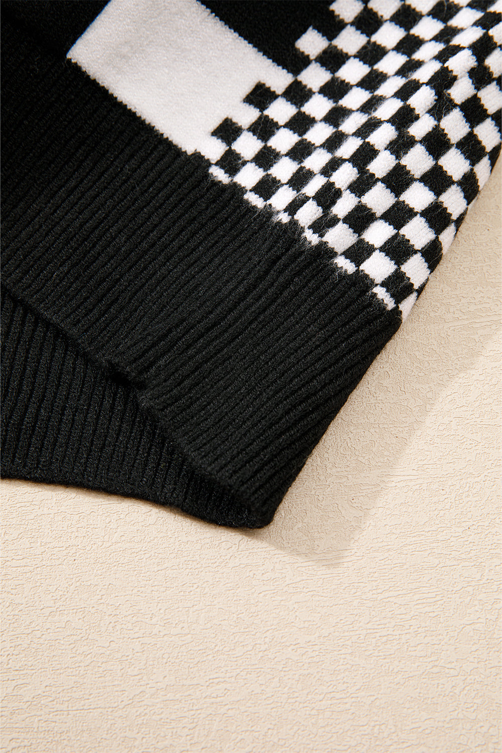 Schwarzer Pullover mit Karomuster und überschnittener Schulterpartie und Rundhalsausschnitt