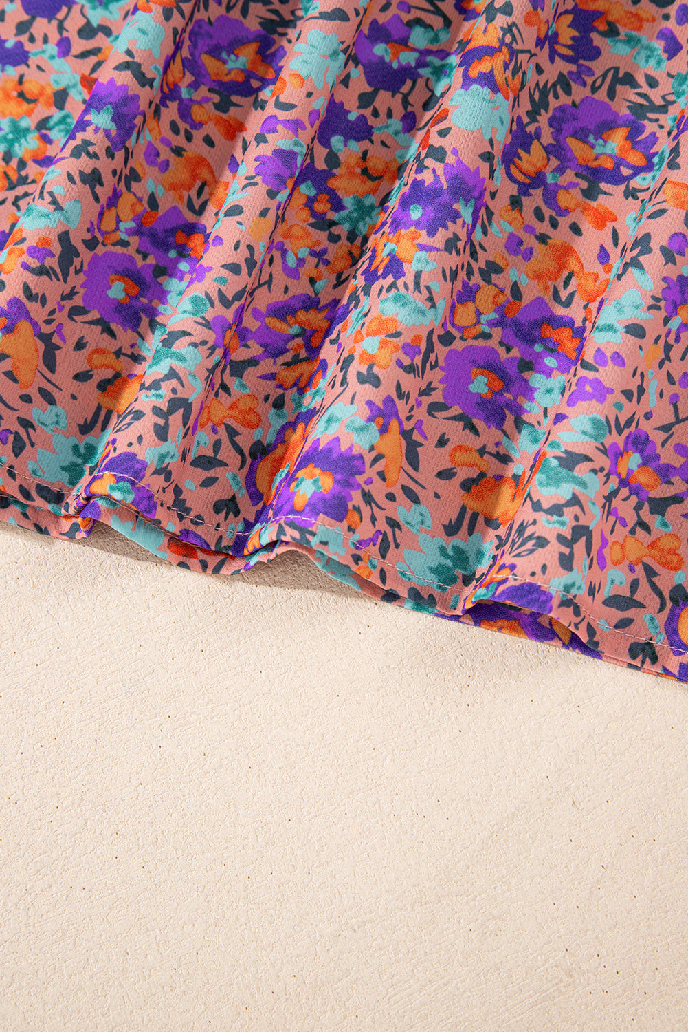 Lila Bluse mit Rundhalsausschnitt, Blumenmuster und gerafften Bündchen