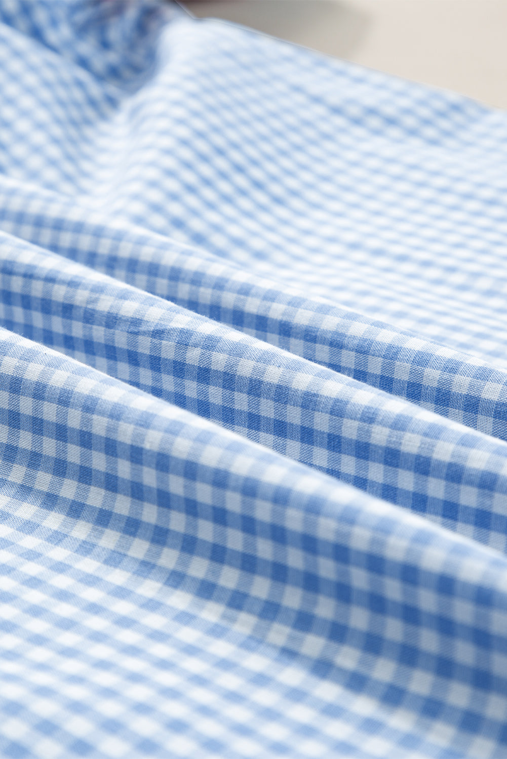 Hellblaue Bluse mit Puffärmeln und Blumenstickerei im Gingham-Stil