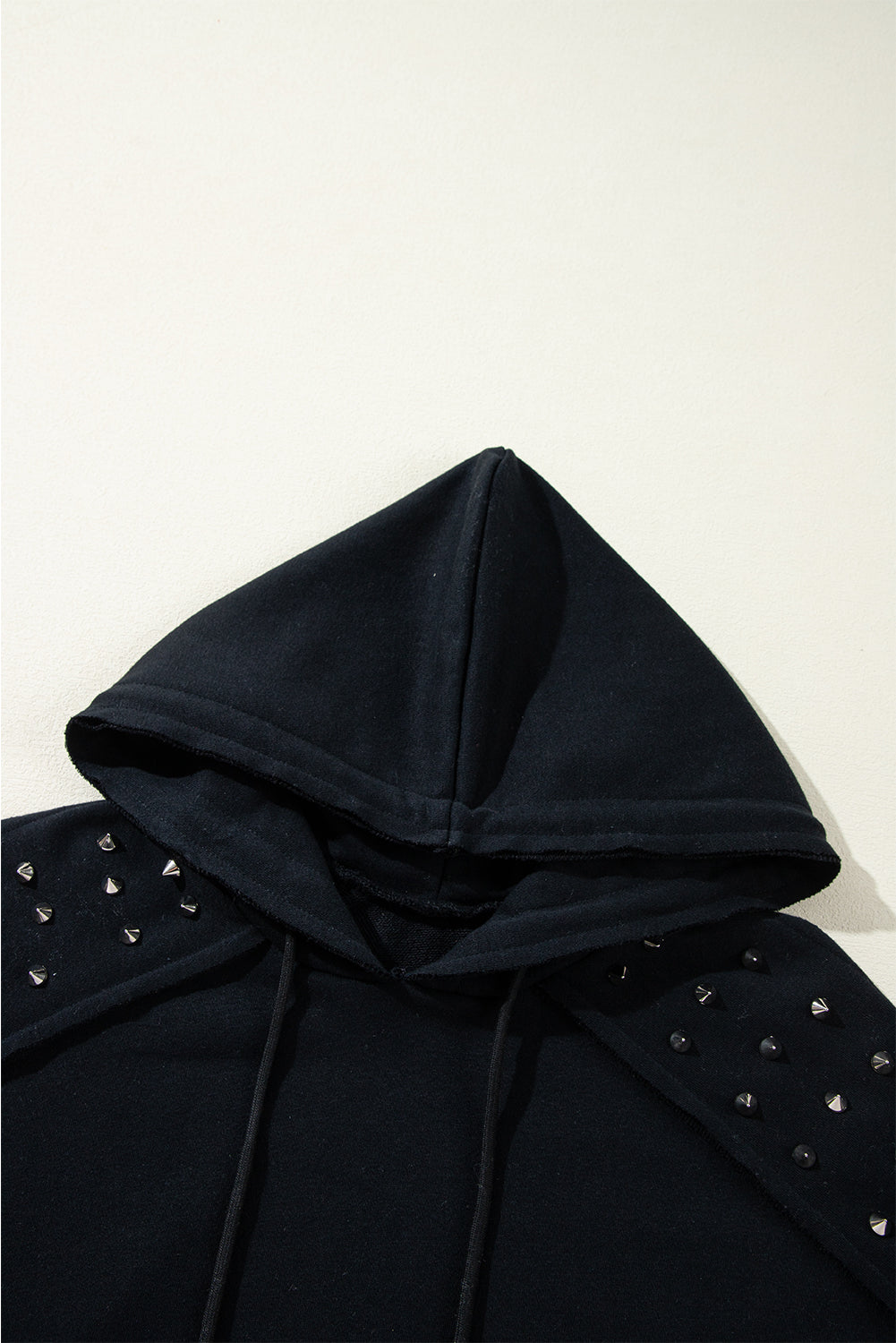 Schwarzer, einfarbiger Kapuzenpullover mit Raglanärmeln und Nieten und Tasche