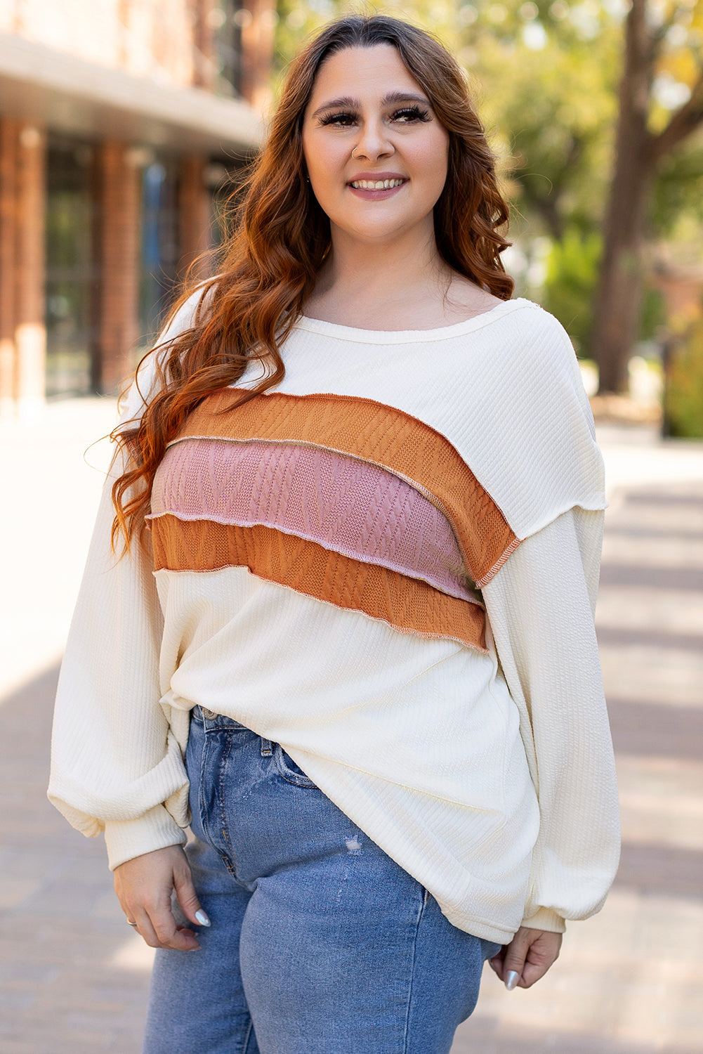 Weißes Stricktop mit Patchwork-Muster und sichtbaren Nähten sowie langen Ärmeln