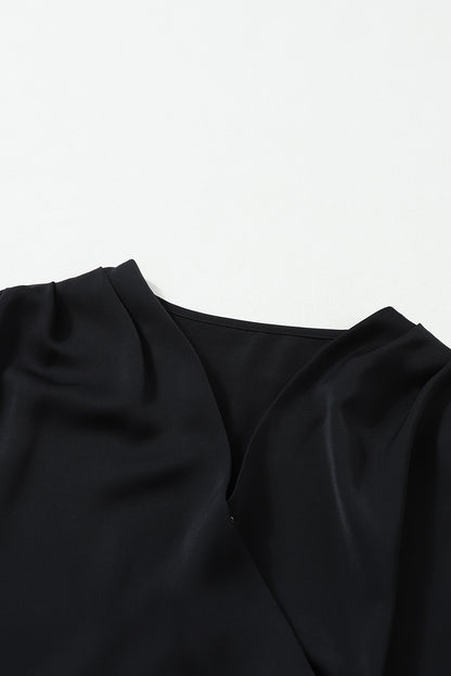 Schwarze, einfarbige Bluse mit Überwurfkragen und gerafften Bündchen