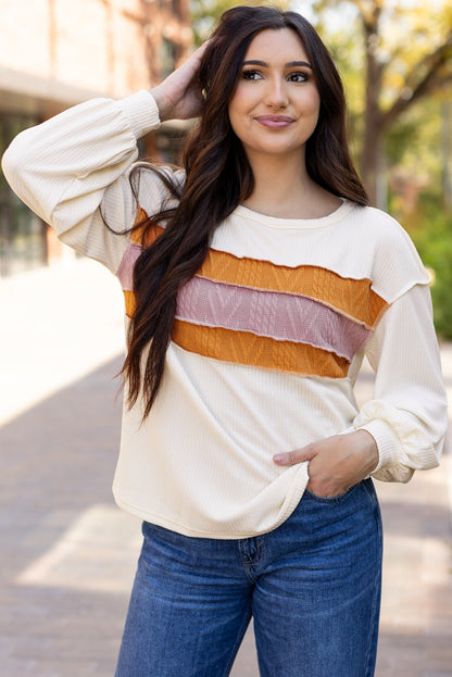 Weißes Stricktop mit Patchwork-Muster und sichtbaren Nähten sowie langen Ärmeln