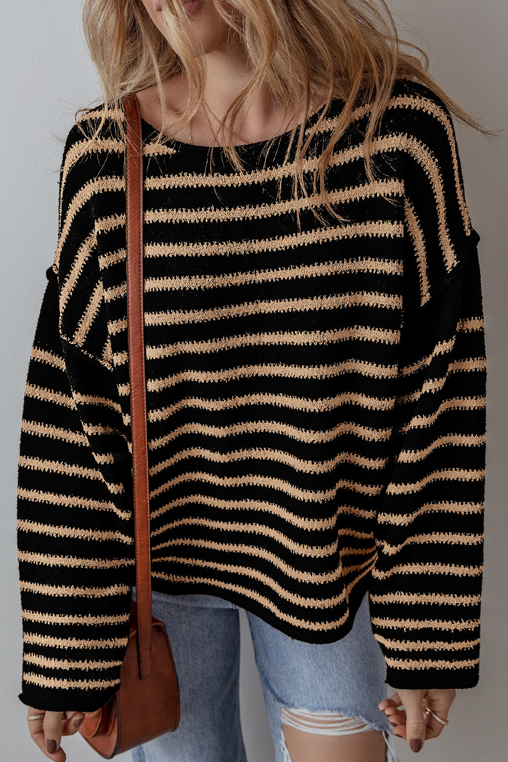Schwarzer Pullover mit Streifen, tief angesetzter Schulterpartie und Rundhalsausschnitt